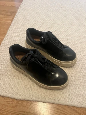 Svarta sneakers med vit sula - Stilrena svarta sneakers från eytys med klassisk låg profil och vit, tjock sula. Skorna har svarta skosnören och ovandel i slätt läder. Använd två gånger därav som nya i kvaliten. Skokartong och alla äkthets bevis tas med såklart🤗 Nypris 2200