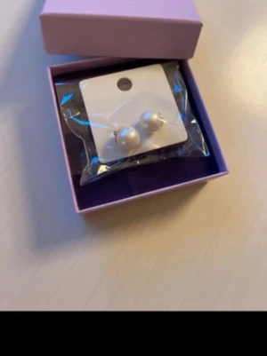 Pärlörhängen! Nya i förpackning!  - Pärlörhängen från Mellow Moon  Örhängen från Mellow Moon med förgyllt utförande och krämvita glaspärlor.  18 karat förgyllt mässing med pärlor    Guld och krämvit  Material: 18 karat förgylld mässing. Färg: Guldfärgad, Krämfärgad, Vit  Nypris 295kr 