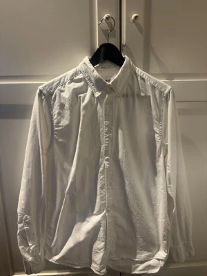 Vit skjorta med knappar - Klassisk vit skjorta med krage och knäppning framtill. Långärmad modell i bomull, perfekt för en clean och stilren look. Passar till många olika outfits och är ett måste i garderoben.