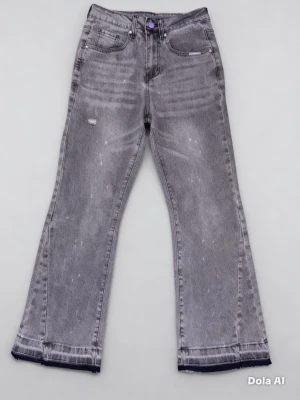 Grå bootcut jeans med slitningar - Snygga grå jeans med bootcut passform och slitna detaljer. Jeansen har en tvättad look med ljusa partier och råa kanter vid bensluten. Klassisk femficksmodell och knappgylf. Perfekta för en trendig och avslappnad stil.