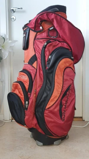 Sun Mountain C-130 Golfbag ord pris 4500 kr/ Golf / bag - Sun Mountain C-130 golfbag i rött och orange. Bagen har flera fack för klubbor och förvaring, samt en axelrem för enkel transport. Designad för att vara funktionell på golfbanan.