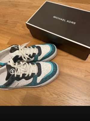 Men's Michael Kors Baxter Color-Blocked Logo Sneaker in the "Blue Multi" - Brand: Michael Kors Style Name: Baxter Sneaker Material: Signature-print canvas and Nappa leather blend Design: A '90s-inspired, color-blocked, low-top silhouette with a streamlined rubber sole. Color: Blue Multi/Petrol Blue/Medium Blue  Comes with the original shoe box.   Used only two times unfortunately not my style anymore. Buying price 2000kr Feel free to ask questions.from smoke free and pet free house. Text me,We can discuss the price.