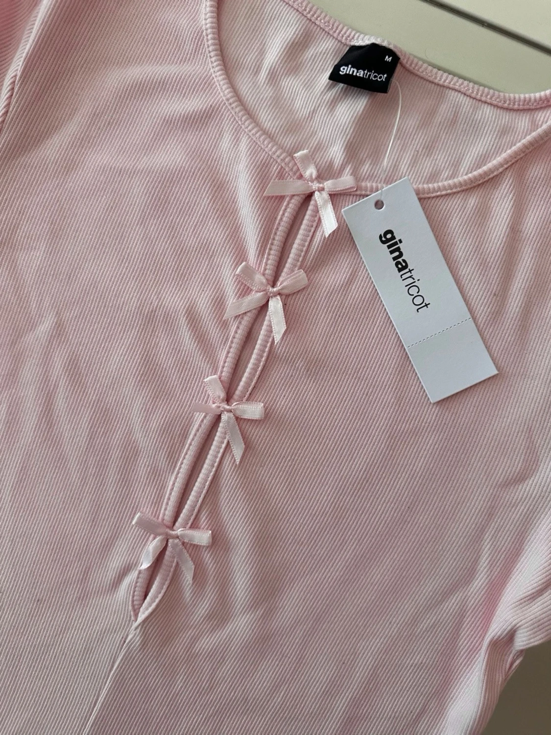 Ljusrosa ribbad topp med rosetter