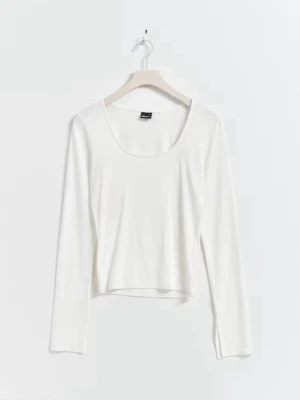 Vit  långärmad topp - Snygg vit långärmad topp med rund halsringning. Modellen är croppad och passar perfekt till både jeans och kjol. Tillverkad i mjukt material som känns skönt mot huden.