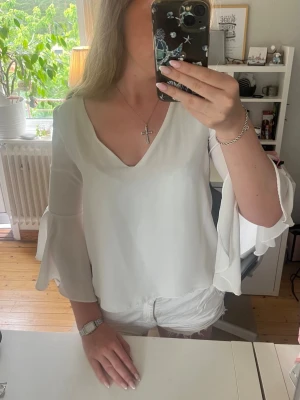 Vit blus - Super söt blus från Zara. Blusen har öppen rygg och volangärmar. 