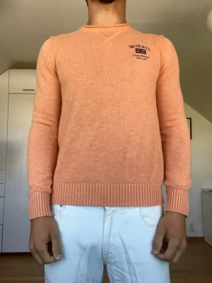 Aprikosfärgad stickad tröja  - Aprikosfärgad stickad tröja från Morris tillverkad i 100% bomull. Strl S. Inga defekter. Modellen är 178 cm och väger 77 kg. Hör gärna av dig vid frågor!