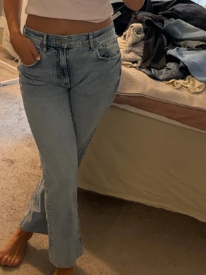 Ljusblå raka jeans med hög midja - Säljer ett par ljusblå jeans med rak passform och hög midja. Jeansen har klassiska fem fickor och stängs med dragkedja och knapp. Tillverkade i denim med en avslappnad vibe, perfekta till en enkel t-shirt eller hoodie.