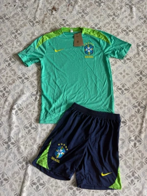 Brasilien fotbollsträningsset Nike - Brasilien fotbollsset i storlek S. Shortsen har fickor med dragkedjor. Helt nya och oanvända, Hör gärna av vid frågor!