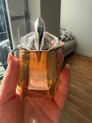 Mugler Alien Godess EdP 30ml - Alien från Mugler är en ikonisk parfym i en unik, bärnstensfärgad flaska med futuristisk design och silverdetaljer. Flaskan har en kristalliknande form och rymmer 30 ml Eau de Parfum. Perfekt för dig som gillar dofter med karaktär och stil. Testad en gång