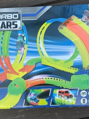 Turbo Stars Glowing Racebana - Säljer en Turbo Stars Glowing Racebana med 177 delar och en total längd på 350 cm. Banan har färgglada, böjbara delar i neonfärger och inkluderar loopar och kurvor. Perfekt för att köra med små bilar och skapa häftiga banor som lyser i mörkret.