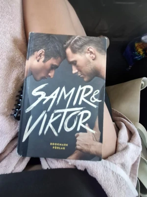 Samir & Viktor bok Bookmark Förlag - En snygg bok med titeln 'Samir & Viktor' från Bookmark Förlag. Signerad av både samir och viktor. Omslaget är svart med stora vita bokstäver och ett foto på Samir och Viktor. Boken har hårda pärmar och cool grafisk design. Perfekt för dig som gillar biografier och populärkultur.