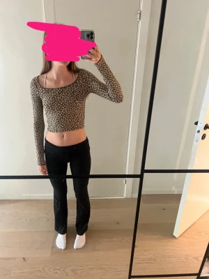 Leopardmönstrad croppad topp - Säljer en croppad topp med leopardmönster och långa ärmar. Toppen har en tight passform och bred, rund ringning. Perfekt för dig som vill sticka ut med ett djuriskt print.