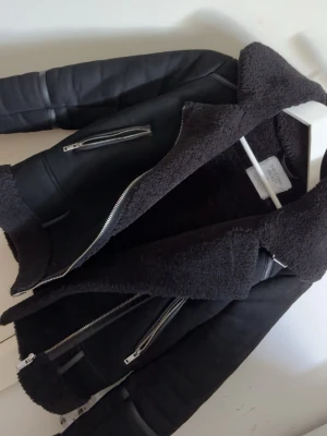 Mocka jacka från stradivarius  - Super fin jacka från stradivarius i mocka. Fått super mycket komplimanger varje gång ja haft den. Väldigt snålt använd, inga defekter. I storlek XS. Vet dock inte varför de ser ut som ”pälsen” är lite grå på bilden men det är svart i verkligheten. 