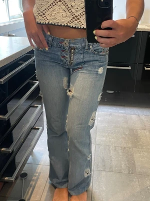 Diesel jeans med hål - Säljer ett par ljusblå diesel jeans med bootcut-modell och massa coola slitningar och hål (det är modellen). Lite korta på mig som är 172, därav säljer. Asnajs jeans annars!! Jag har oftast 34/36 i jeans! Inte använda så ofta. 