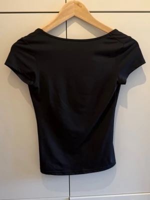 Svart topp med djup rygg - Svart tajt topp med djup rygg från Weekday