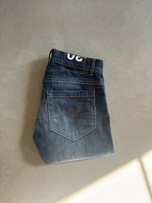 Dondup mörkblå - Ett par mörkblåa dondup Georg som har ljus fade vid knäna, det är ett par väldigt fina jeans i bra skicka och dem är 101 cm långa dem är i ganska hårt material, tveka inte att höra av dig 