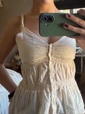 Beige linnetopp med knappar - Söt beige linnetopp med smala axelband och knappar framtill