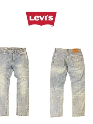 Levi's ljusblå raka jeans - Klassiska ljusblå jeans från Levi's med rak passform och fem fickor. Jeansen har råa, fransiga benslut och den ikoniska röda Levi's-lappen på bakfickan samt läderpatch i midjan. Tillverkade i slitstark denim, perfekta för en avslappnad och trendig look.