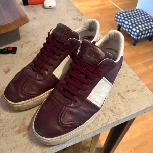 Vinröda Valentino sneakers - Snygga flycrews för dig som vill sticka ut lite med färgval! Skorna är använda och endast 3 nitar borta. Skorna är i st 42 men passar 43