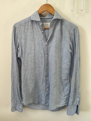 Linneskjorta Eton  - As snygg ljusblå linneskjorta från Eton som gör ont att sälja. 10/10 skick. Storleken är 36 vilken motsvarar S, slimfit. Köpt för 2000, säljer för 599. 