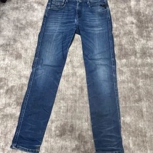 Blå raka jeans från replay  - Snygga blå jeans från replay med raka ben och klassisk femficksmodell. Jeansen har en tvättad look med ljusare partier och kontrastsömmar. Tillverkade i denim med en cool patch bak i midjan.
