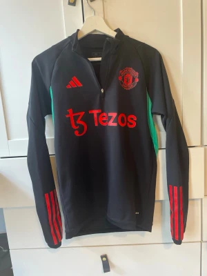 Manchester United träningströja Adidas - Snygg svart Manchester United träningströja från Adidas som är i väldigt bra skick och andvänd få gånger