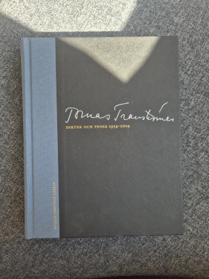 Tranströmer: Dikter och prosa 1954-2004 - Snygg samlingsvolym med dikter och prosa av Tomas Tranströmer från 1954 till 2004. Boken har hårda pärmar i mörkgrått med ljusblå rygg och guldfärgad text på framsidan. Perfekt för dig som gillar svensk poesi och klassiker.