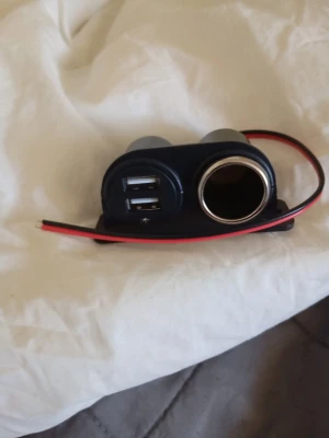 USB och 12V uttag till bil - 12V-billaddare med dubbla USB-portar och ett extra cigarettändaruttag, ofta monterad för att ge ström till telefoner, surfplattor eller GPS-enheter.  Funktioner: Innehåller två USB-laddningsportar och ett extra uttag för 12V-tillbehör.  Montering: Designad för fast montering med tillhörande kablar (röd/svart) för anslutning till fordonets elsystem.  Kompatibilitet: Passar för bilar, båtar, husvagnar och motorcyklar med 12V-system.  Specifikationer: Många liknande modeller erbjuder upp till 5V 3.