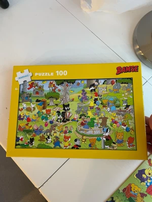 Bamse pussel 100 bitar - Säljer ett färgglatt Bamse pussel med 100 bitar i en gul kartong. Motivet visar Bamse och hans vänner på en fest i en grönskande park med ballonger och lek. Perfekt för dig som gillar klassiska svenska serier och pussel.