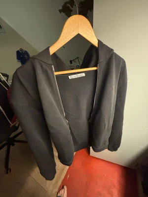Svart hoodie med dragkedja Acne Studios - Säljer en svart hoodie från Acne Studios med dragkedja framtill och huva. 100% bomull och knappt använd. Liten i storleken. nypris 3600kr
