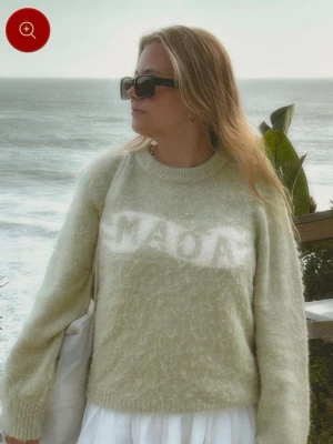 Ljusgrön stickad tröja från Mads Nørgaard - Mysig ljusgrön stickad tröja från Santana Maoa med fluffig struktur och rund hals. Tröjan har ett vitt logotyptryck framtill och broderad text i nacken. Perfekt för lager på lager och chill stil. ord pris 649