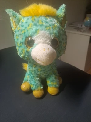 Gosedjur enhörning turkos och gul - Söt enhörning som gosedjur i mjuk plysch. Den är turkos med gula prickar, har stora glittriga ögon, gul man och svans samt vita detaljer på nosen. Perfekt som dekoration eller mysigt sällskap i soffan.