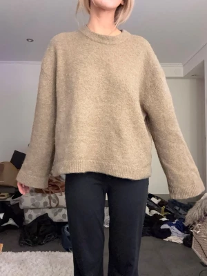 Beige stickad tröja - Mysig beige stickad tröja med oversized passform och rund halsringning. Tröjan har långa ärmar och ribbstickade muddar vid ärmslut och nederkant. Super snygg och lätt att styla!