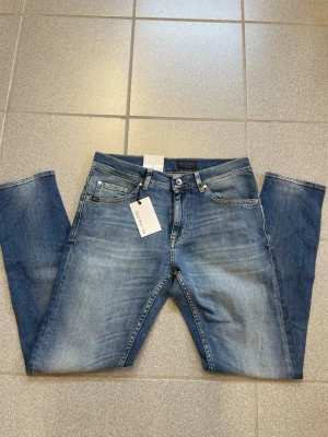 Blå tiger of Sweden jeans  - Snygga blå jeans från tiger of Sweden  med raka ben och klassisk femficksmodell. Jeansen har en lätt tvättad look och är tillverkade i bomull med en skön passform. Perfekta för en avslappnad stil och enkla att matcha med olika plagg.