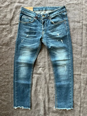 Blå Dondup jeans med slitningar, storlek 30 - Blå Dondup George jeans med schyssta slitningar och fades Jeansen är i storlek 32 men uppskattas sitta som 30 Hör av er vid frågor!