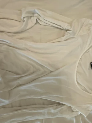 Vit långärmad topp i sammet - Säljer en vit långärmad topp i mjuk sammet med rund halsringning. Perfekt för dig som gillar en enkel men ändå lyxig look. Passar till många olika stilar och är superbekväm att bära.