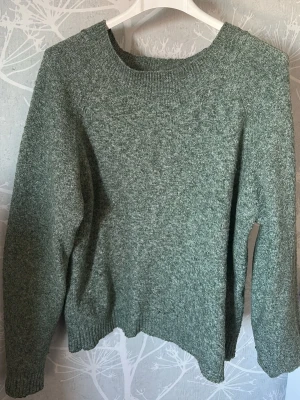 Grön stickad tröja - En enkel grön stickad tröja med rund halsringning och långa ärmar.