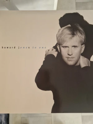 Howard Jones To One vinyl - Lp Howard Jones. Albumet 'Howard Jones To One' med minimalistisk design i beige och svart. Framsidan har ett konstnärligt foto av Howard Jones och baksidan visar en siluett. Perfekt för dig som gillar klassisk pop och samlar på LP-skivor. Inga repor.