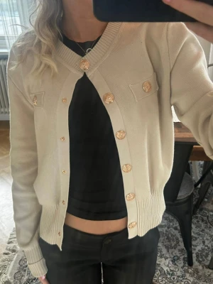 Beige kofta med guldknappar - Stilren beige kofta med dekorativa guldknappar och två fejkfickor framtill. den är ifrån Frankrike och står XL men jag har Xs och den passar Xs-S🌸