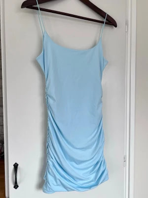 Y2K ljusblå rouched miniklänning med spaghettiband, stl S - Babyblå kort klänning med tunna band och rynkade sidor. Enkel och stilren design och perfekt nu till sommaren! Stretchig och mjuk, aldrig använd.