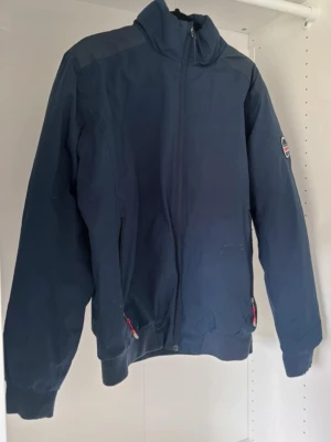 Marinblå herrjacka - Herrjacka i fint skick, har några små hål som syns på bilderna men är i det stora hela fin. Lite nopprig på muddarna. Cirka 62cm lång i framsida, cirka 60cm i ärmar.