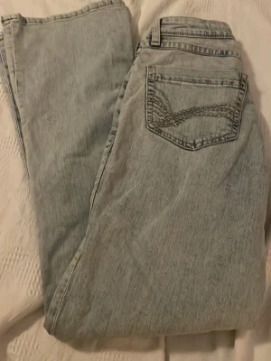 Ljusblå jeans med broderad bakficka - Snygga ljusblå jeans med coolt broderi på bakfickan. Jeansen har klassisk femficksdesign och är gjorda i denim. Perfekta för dig som gillar en avslappnad och trendig look.