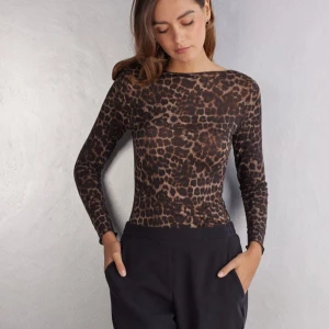 Leopardmönstrad långärmad topp - Snygg långärmad topp med leopardmönster i bruna och svarta toner. Figurnära passform och rund halsringning. Perfekt för dig som vill sticka ut lite extra. Tillverkad i mjukt och stretchigt material som sitter skönt på kroppen.