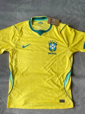 Brasilien matchtröja  - Säljer en riktigt clean Brasilien-tröja f 💛💚 Helt ny med tags kvar och sjukt snygga detaljer i tyget.  • Landslag: Brasilien 🇧🇷 • Modell: Matchtröja / supportertröja • Storlek: M (L passar som M) • Skick: Helt ny med tags • Fina invävda mönster över hela tröjan • AeroFit-material – lätt och skön  Perfekt till fotboll, sommaren eller bara som streetwear-fit ⚽️  💰 Pris: 350 kr 📍 Kan mötas / skickas 