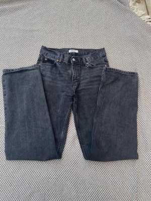 Svarta raka mörkgråa från Levi's - Snygga mörkgråa jeans från Levi's med rak passform och klassisk femficksdesign. Jeansen har låg midja och är tillverkade i kraftig denim. Perfekta för en avslappnad och trendig stil.