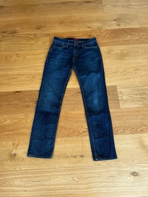 Mörkblå slim fit jeans - Snygga mörkblå slim fit jeans med klassisk femficksdesign och subtila slitningar. Jeansen har raka ben och kontrastsömmar, perfekta till en avslappnad look. Tillverkade i denim med stretch för extra komfort. Regulate/clark storlek W30 L32 