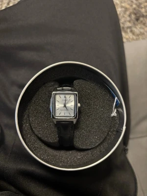 Casio fyrkantig klocka i silver - Casio armbandsklocka med fyrkantig silverfärgad urtavla och svart armband. Helt oanvänd.