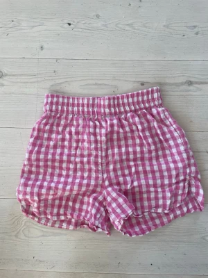 Rosa & vit rutiga shorts - Säljer ett par rosa & vit rutiga shorts i stretchigt material