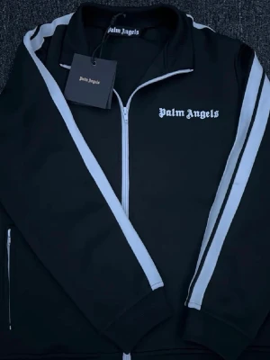 Palm Angels Zip-Up - Plagg:Palm Angels Zip-Up Storlek:S Passar M Mitt pris:499 Skick:10/10 Helt Ny Märke/Brand:Palm Angels Färg:Svart/Vit Passform:S-M Övrigt:Hel Ny Aldrig Använd  Fraktar Inom 24 h📦 Skriv Vid Minsta Lilla Intresse😃 