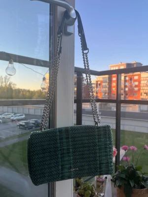 Grön axelväska Parfois - Snygg grön axelväska med mönstrad yta och silverfärgad kedjerem. Köpt i Spanien, sparsamt använd🌸